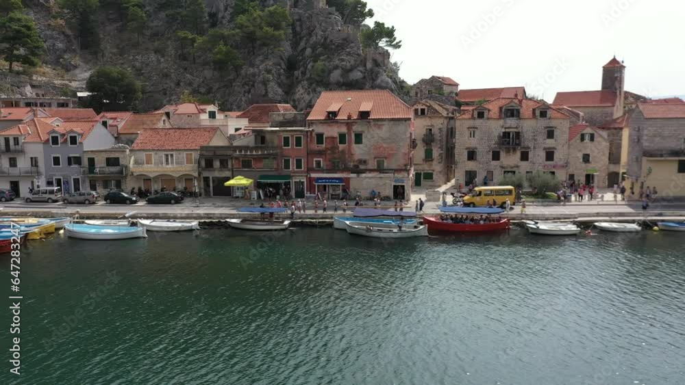Old towns of Croatia. Summer holidays. Yachting. Cetina River winding its way through Rugged mountains gorge into adriatic sea in Omis Town. Aerial. Morning Old towns of Croatia. Summer holidays. Yachting. Cetina River winding its way through Rugged mountains gorge into adriatic sea in Omis Town. Aerial. Morning