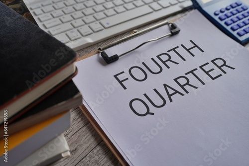 Close up image of paper clipboard with text FOURTH QUARTER on office desk photo