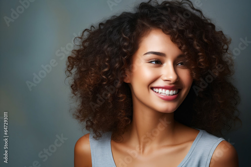 Woman with smile on her face and curly hair.