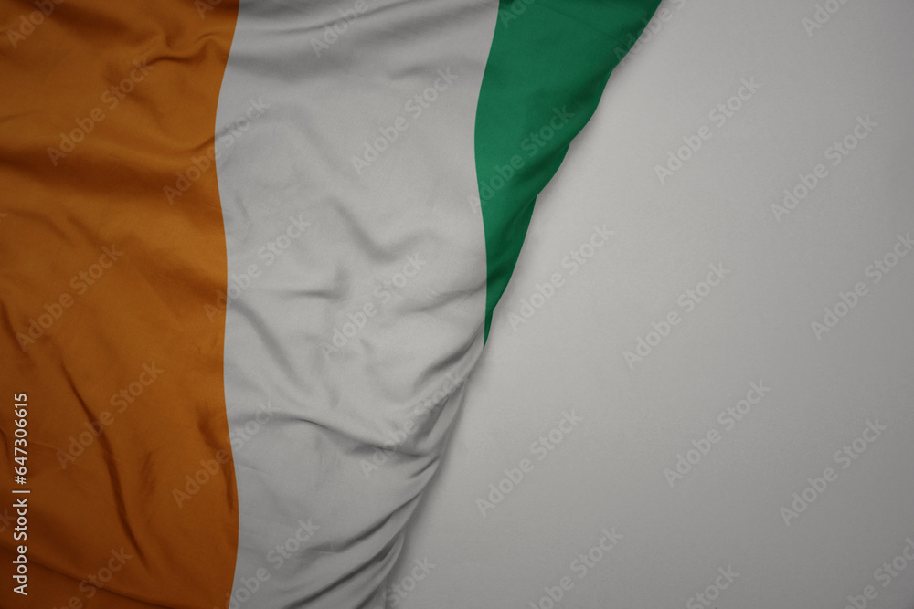 big waving national colorful flag of cote divoire on the gray background. big waving national colorful flag of cote divoire on the gray background.