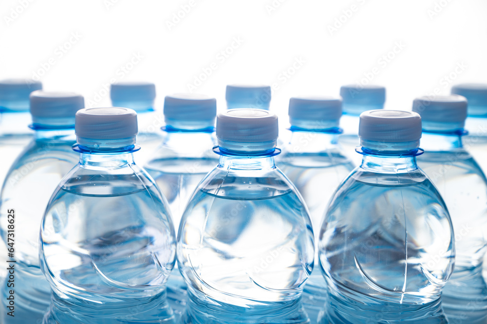 Transparent blue plastic bottles containing water, next to each other. Use and recycling of plastic, environmental protection. Transparent blue plastic bottles containing water, next to each other. Use and recycling of plastic, environmental protection.