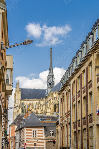 Cathedral Basilica of Our Lady of Amiens Roman Catholic church Notre-Dame behind buildings on street in historical city centre, vertical view, Somme department, Hauts-de-France Region, France