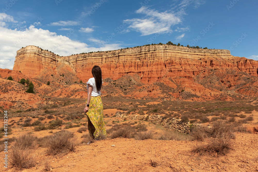 Woman walking through the Red Canyon of Teruel, also known as Rambla de Barrachina