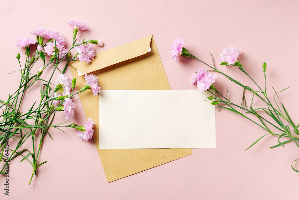 Blank greeting card and carnation flowers on the pink background.