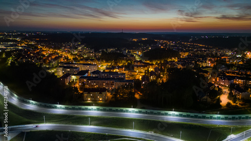 Widok z lotu ptaka miasta Gdynia podczas zachodu słońca, zdjęcia zrobione dronem, neony światła nocnego miasta i ulic
