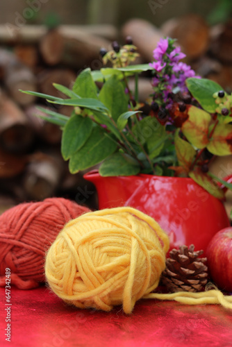 Cozy autumn still life with red apples and woolen yarn balls. Hobby and leisure concept. 