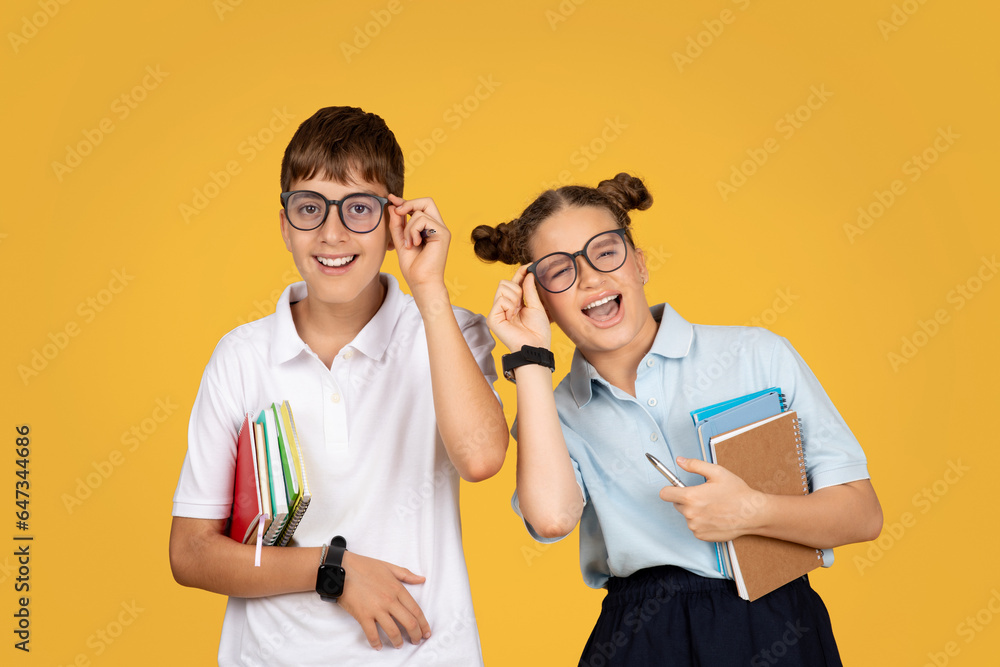 Laughing european teenager schoolchildren in glasses with books have fun at school, enjoy education Laughing european teenager schoolchildren in glasses with books have fun at school, enjoy education