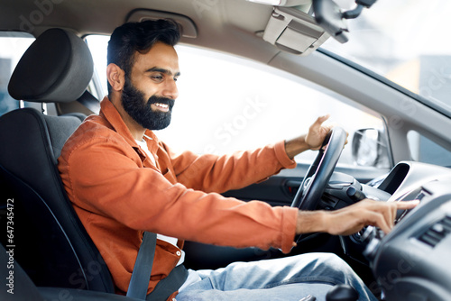 Indian Man Pushing Button Turning On Music Enjoying Automobile Journey © Prostock-studio
