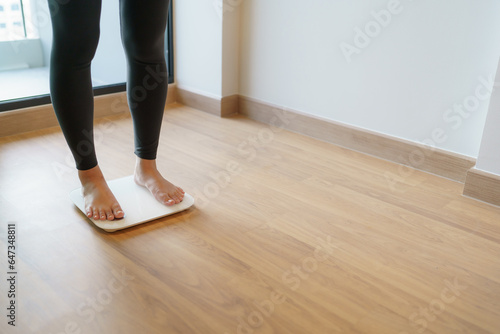 Lose weight. Fat diet and scale feet standing on electronic scales for weight control. Measurement instrument in kilogram for diet.