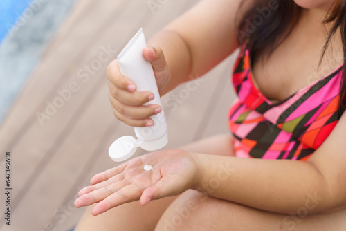 Obese Woman applying sunscreen cream Vacation Traveling with Body Sun protection suncream in hotel resort holiday .