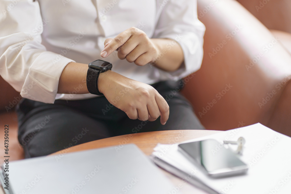Business woman Looking at smart watch In Office online connect Gadget technology.
