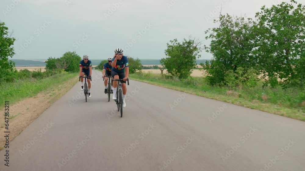 Three happy male triathlete cyclists racing bicycles and take photo on cell phone in summertime Three happy male triathlete cyclists racing bicycles and take photo on cell phone in summertime