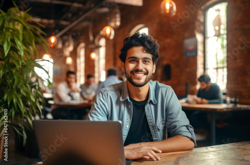 Portrait of cheerful male it professional working remotely with modern laptop device sitting at table and smiling at camera during break. AI Generated