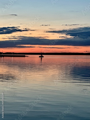 A boat, yacht, ship on a lake with an orange-red sunset