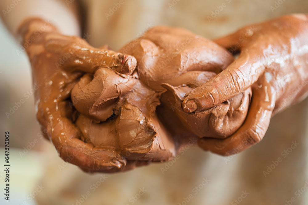 Detail of a ceramist woman's hands molding the clay