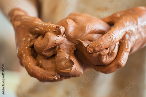 Detail of a ceramist woman's hands molding the clay photo