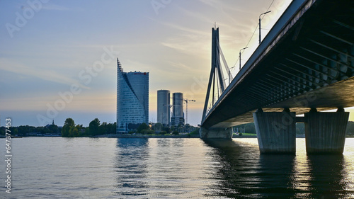 Most Vansu o zachodzie słońca przechodzący przez rzekę Dźwinę w mieście Ryga - stolica Łotwy #647377453