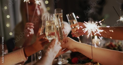 A friendly family clinks glasses of sparkling wine at the festive table.