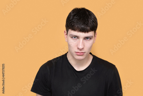 Sad disappointed young guy on yellow background, the guy is disappointed in his friends, feels anxiety and heartache, depression. Guilt in a young guy
