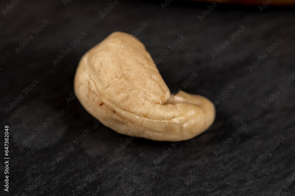 peeled cashew nuts on a black slate board, close-up peeled cashew nuts on a black slate board, close-up