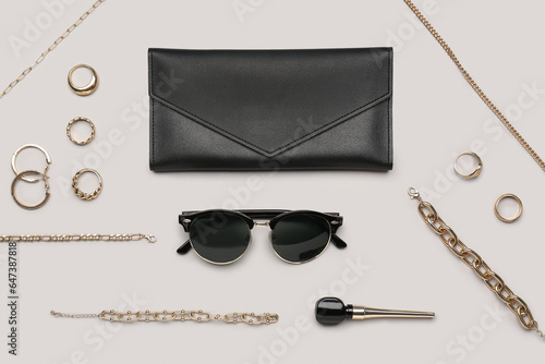 Stylish sunglasses with beautiful jewellery on grey background