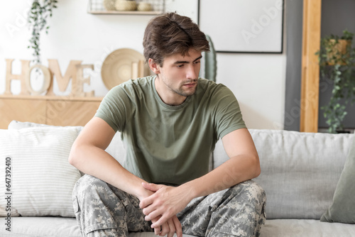 Young male soldier sitting on sofa at psychologist's office