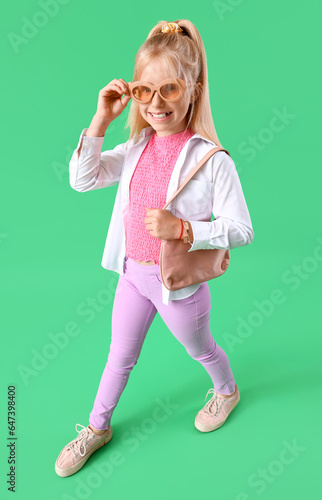 Stylish little girl on gree...