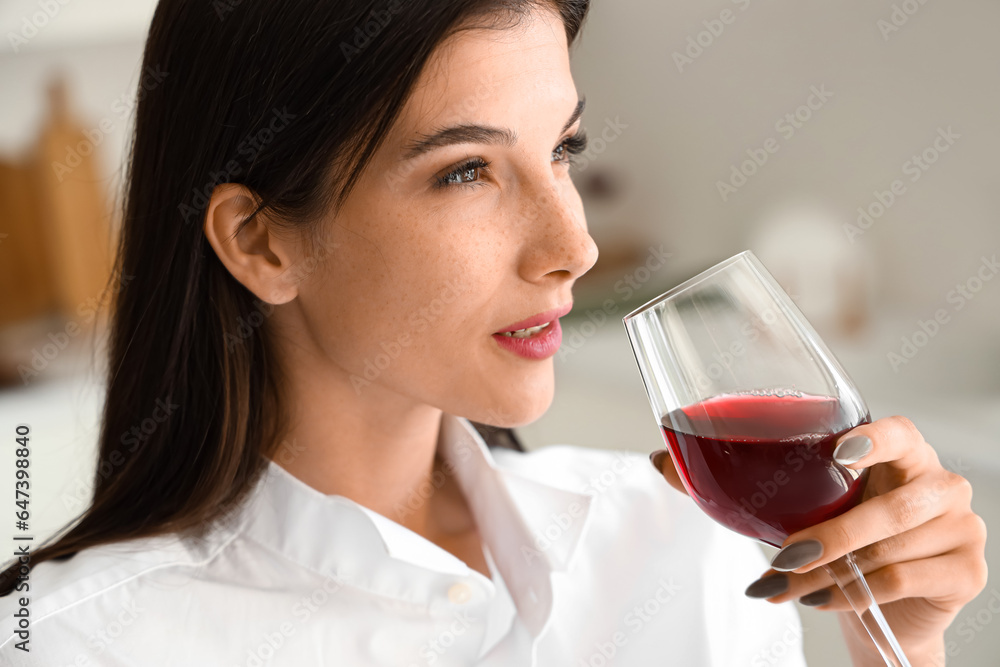 Young woman with glass of wine in kitchen, closeup Young woman with glass of wine in kitchen, closeup