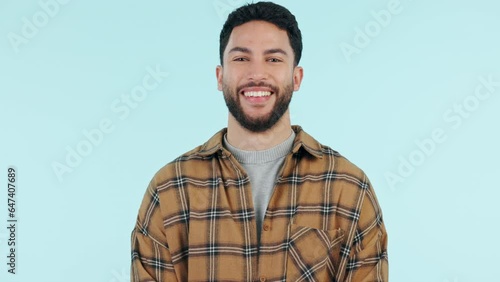 Happiness, man and wink on mockup in studio with confidence, laughing and flirting expression on blue background. Portrait, smile and person with fun personality blink eye for thank you or greeting photo