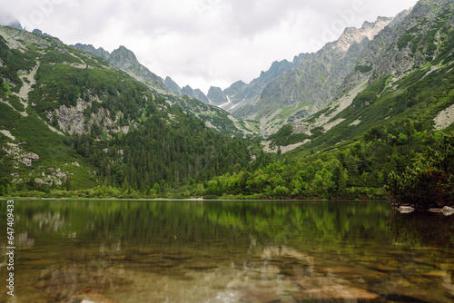 Breathtaking view of the mountains on a hiking trail, among the forest, and an alpine lake. Location of the High Tatras Mountains, Europe. Nature concept, views.