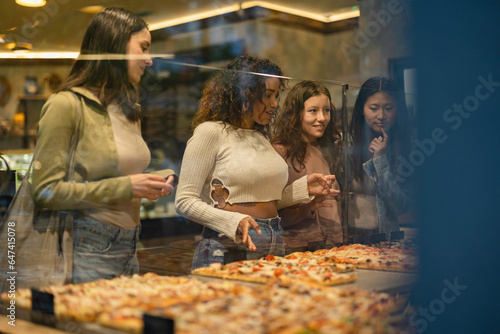 group of women in an Italian restaurant choosing pizza - takeaway -