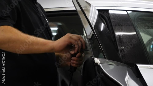 Applying tinting foil on a car window	
