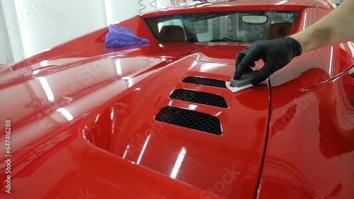 Staff wear Chemical protective clothing at work. Automobile industry. Car wash and coating business with ceramic coating.Spraying the varnish to the car. Concept of: Car protective, Service, Shine.	

