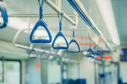 Abstract blurred background of subway train interior, blue handles for passengers, public transportation