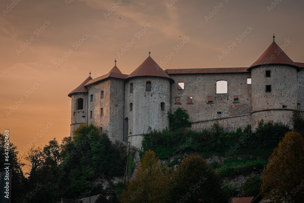 Beautiful Zuzemberk castle lit by evening sun in lat summer. Nice medieval castle in dolenjska region of slovenia, waiting to be rebuilt, rising above krka river.