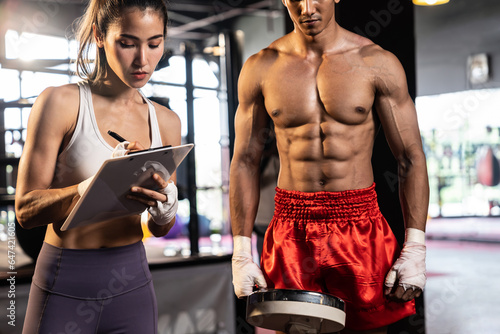 Muay Thai boxer step on weight scale for boxing class designation by weight measurement before boxing fight match. Dedicated athlete fitness and physical boxer's body readiness. Impetus