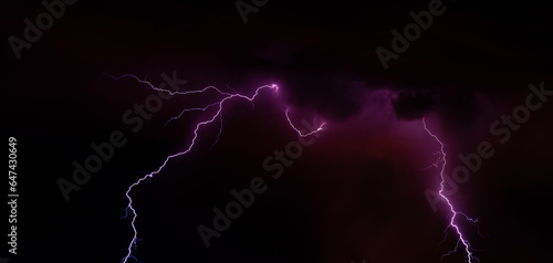 Lightning bolt over night sky . Huge lightning in a purple clouds at night. Night storm with lightning․ © Edgar Martirosyan