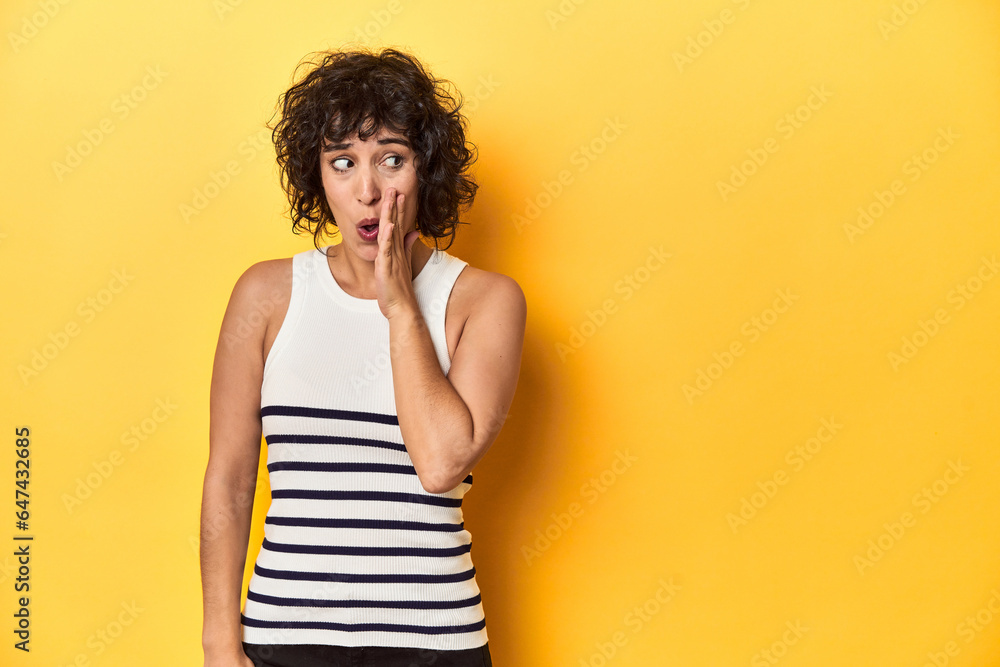 Caucasian curly-haired woman in white tank-top is saying a secret hot braking news and looking aside Caucasian curly-haired woman in white tank-top is saying a secret hot braking news and looking aside