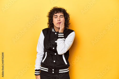 Принти на полотні Curly-haired Caucasian woman in baseball jacket having a strong teeth pain, molar ache