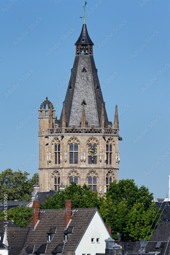 the medieval town hall tower with numerous sculptures of famous people from cologne's history rises high above the old town