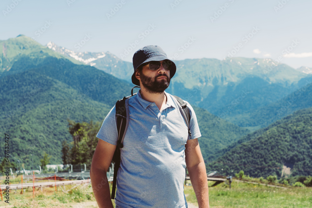 millenial bearded tourist man wearing bucket hat, with backpack trekking in mountains millenial bearded tourist man wearing bucket hat, with backpack trekking in mountains