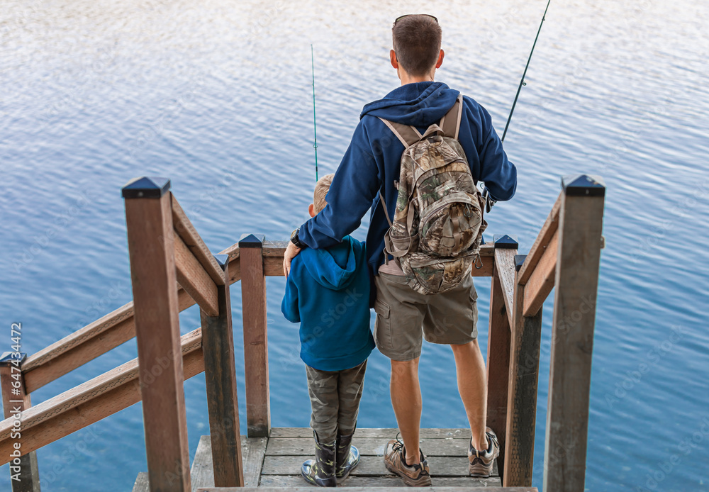 Fototapeta premium Father fishing with son enjoying time together outdoors. Parent child relationship bonding