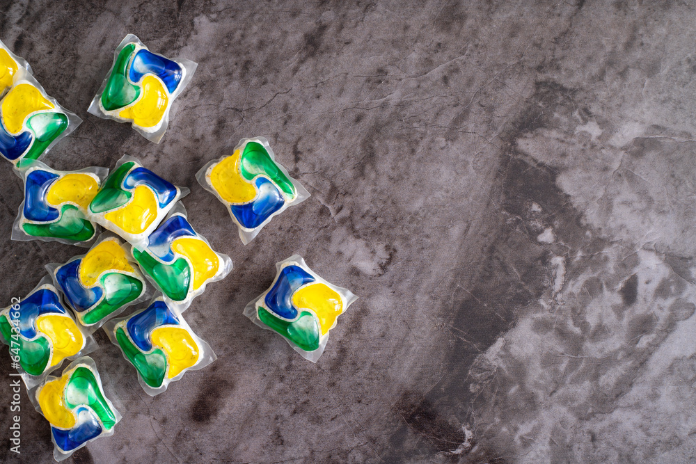 Many dishwasher detergent pods on marble background, flat lay. Space for text Many dishwasher detergent pods on marble background, flat lay. Space for text