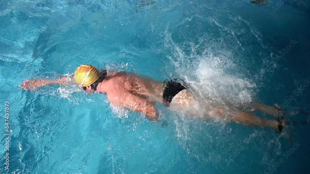 Underwater view of professional swimmer training in swimming pool, 4k 120 fps super slow motion raw video. Triathlete swim in black wetsuit Underwater view of professional swimmer training in swimming pool, 4k 120 fps super slow motion raw video. Triathlete swim in black wetsuit