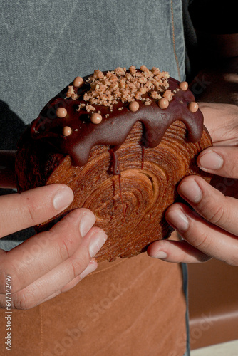 Delicious round croissant with bitter chocolate coating, luxury pastries