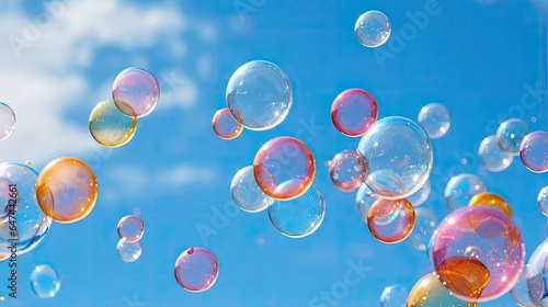 An image of soap bubbles suspended in the air against a bright blue sky.