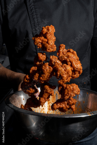 Person cooking some delicious boneless with buffalo sauce