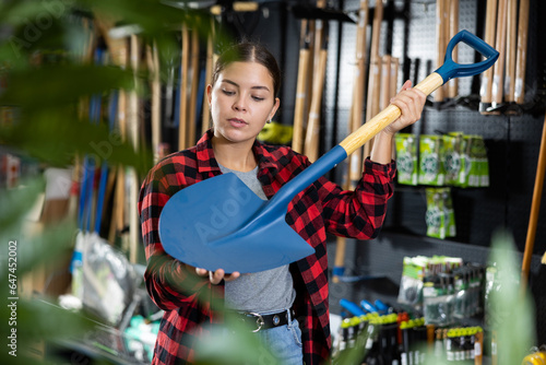 Female farmer choosing shovel in a gardening store