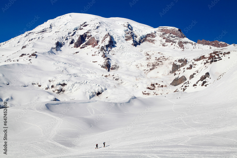 Two cross-country skiers enjoy a sunny day at Mt. Rainier National Park in Washington state in winter
