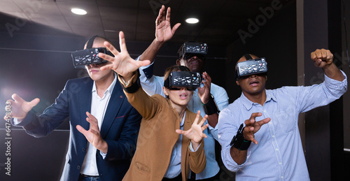 Group of friends are wearing virtual reality goggles in the quest room